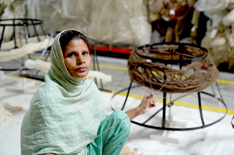 Nargis Khatoon teaching a young woman to weave at a loom in Bhadohi